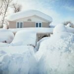 A house surrounded by deep snow drifts after a heavy snowfall