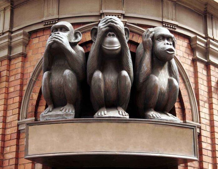 Three monkey sculptures representing see no evil, hear no evil, and speak no evil