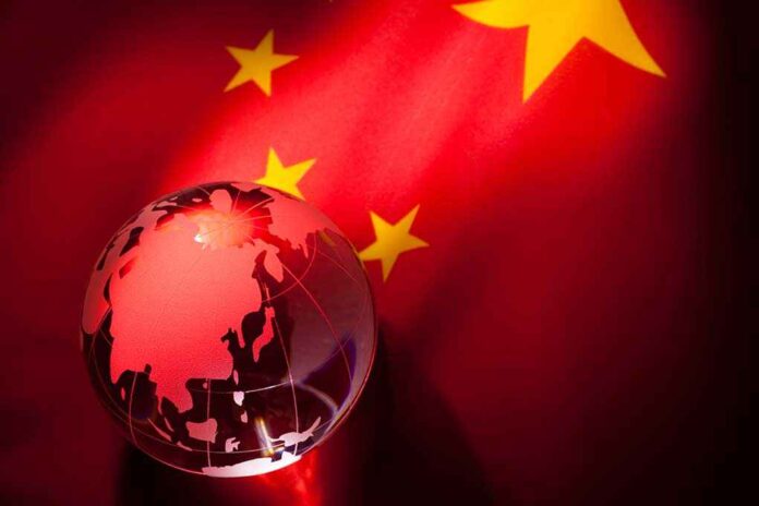 A globe illuminated against the backdrop of the Chinese flag