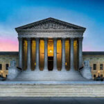 Judge Retirement Rumors Sparks Supreme Court Panic Supreme Court building with illuminated pillars and steps.