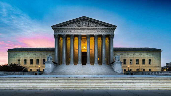 Supreme Court building with illuminated pillars and steps.