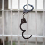 California’s Shocking Parole Decision: Child Predator Freed Handcuffs hanging on a barred window.