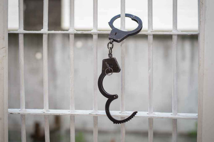 Handcuffs hanging on a barred window.