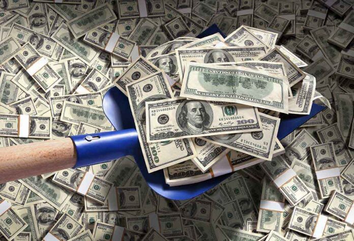 A shovel filled with stacks of cash on a background of scattered dollar bills