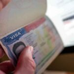 Maryland’s ICE Blockade — Drug Cartels Win Big A hand holding an open passport displaying a visa page