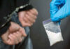 14 Million Fentanyl Doses SEIZED: Crisis Far From Over Person handcuffed, police holding bag of white substance.