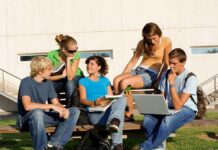 Tech Overhaul Costs $30B— Big Mistake? Group of students sitting on a bench outdoors, engaged in study and discussion