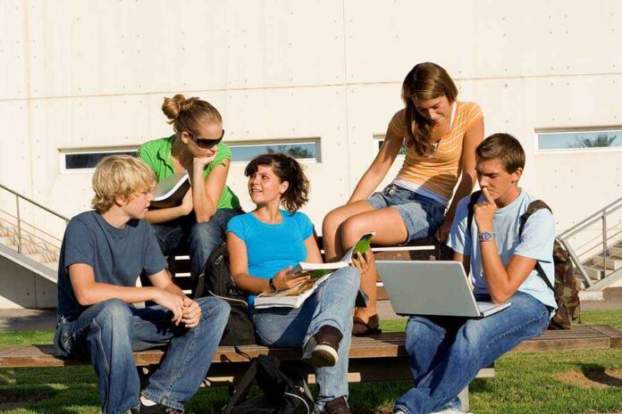shutterstock_15824851.jpg Group of students sitting on a bench outdoors, engaged in study and discussion