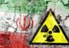 A cracked wall featuring the Iranian flag and a nuclear warning symbol