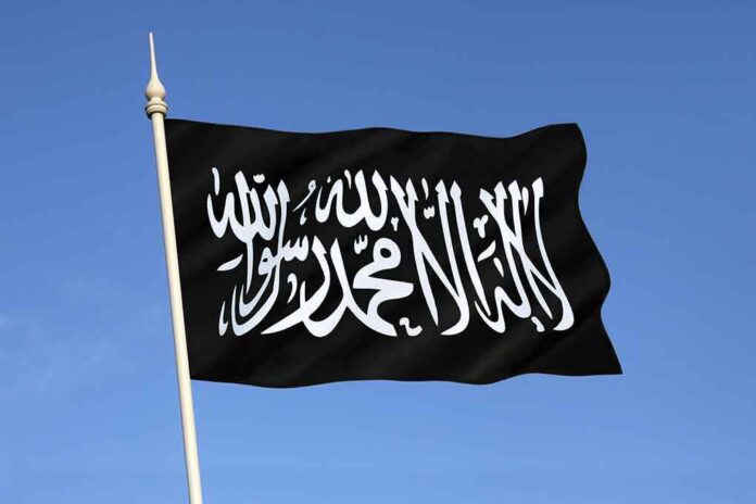 Black flag featuring Arabic script against a blue sky