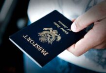 Safe-Country DENIES U.S Asylum Seakers! A person holding a United States passport with a dark background