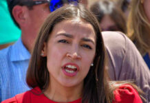 Woman speaking to a crowd outdoors.