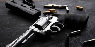 Revolvers and bullets on a dark surface.