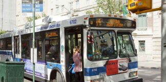 A woman boarding a clean air hybrid electric bus at a city stop