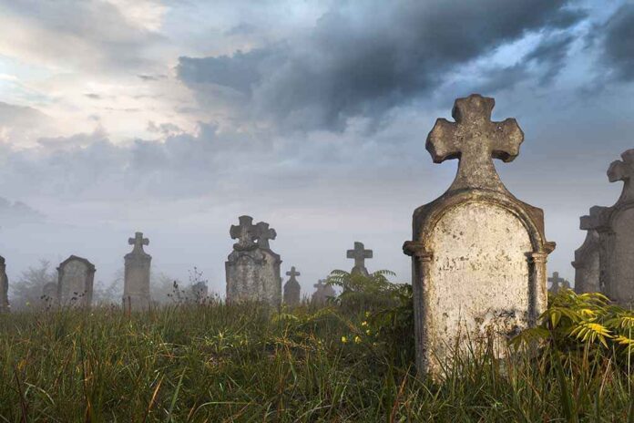 Morning,Quarters,Of,Some,Very,Old,Tombstones,In,A,Very Foggy graveyard with tombstones and crosses under a cloudy sky