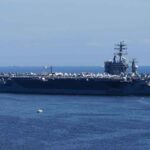 Missile Chess Explodes In The Gulf A large aircraft carrier sailing in the ocean