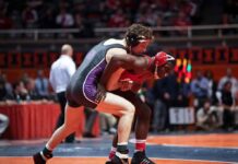 Two wrestlers competing on a mat during a match