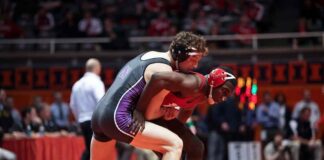 Two wrestlers competing on a mat during a match