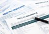 Close-up of health insurance application forms with a pen