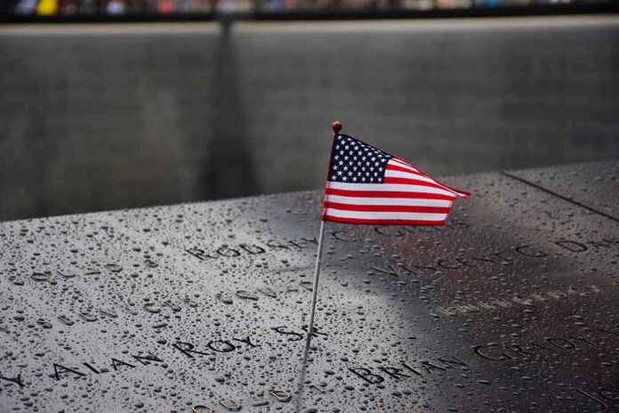 American flag on a rainy memorial nameplate.