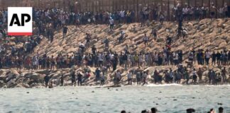 Thousands of migrants swim around the border from Morocco into Ceuta, Spain