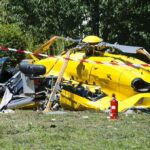 yellow helicopter crash scene on grassy field