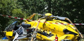 yellow helicopter crash scene on grassy field