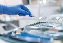 Sicko Dentist Sentenced to Decades in Jail for Child Sex Abuse Gloved hand holding a dental mirror over instrument tray