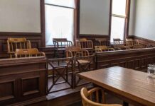 The Number of Noncitizens Summoned for Jury Duty Will STUN You Empty jury box in a courtroom with wooden chairs