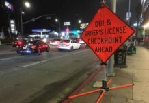 Traffic checkpoint warning sign on city street at night