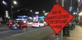 Traffic checkpoint warning sign on city street at night