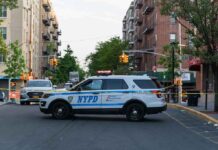 Gang Crossfire Kills Cop’s Son NYPD police SUV blocking a city street at a taped-off scene