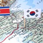 Map of Korean Peninsula with North and South Korean flags and handshake icon
