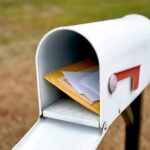 Man ARRESTED For Stealing Ballots Out of Mailboxes! White mailbox with red flag holding envelopes and padded mailers