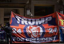 Large political banner at street protest with police nearby