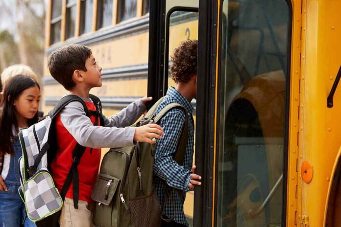 shutterstock_388630477 Children boarding a yellow school bus
