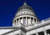 Capitol building dome with columns against a deep blue sky