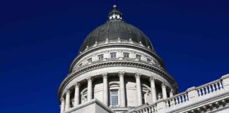 Capitol building dome with columns against a deep blue sky