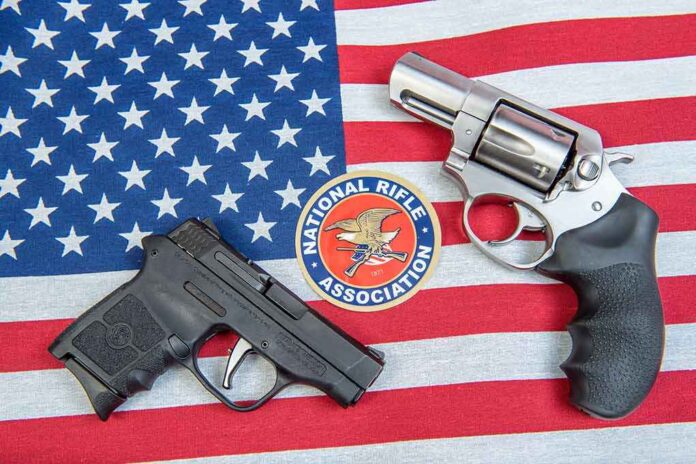 Two handguns and NRA emblem on an American flag