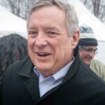 older man smiling at an outdoor event