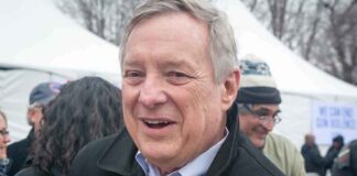 older man smiling at an outdoor event