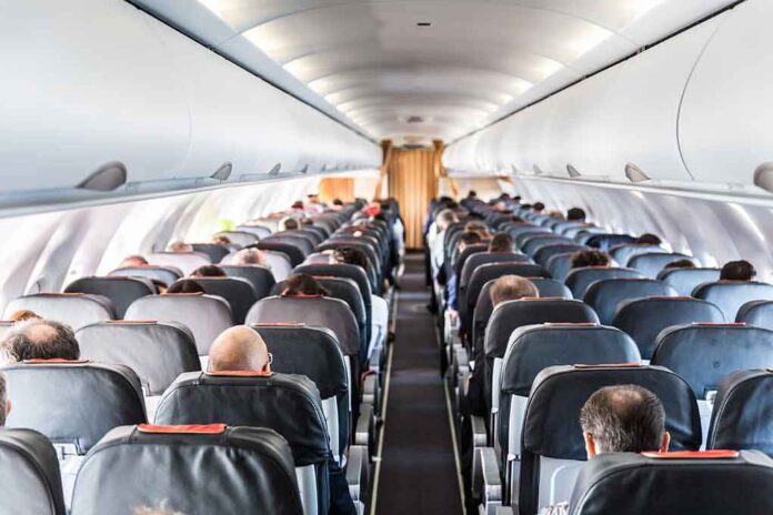 Airplane cabin with passengers seated in rows