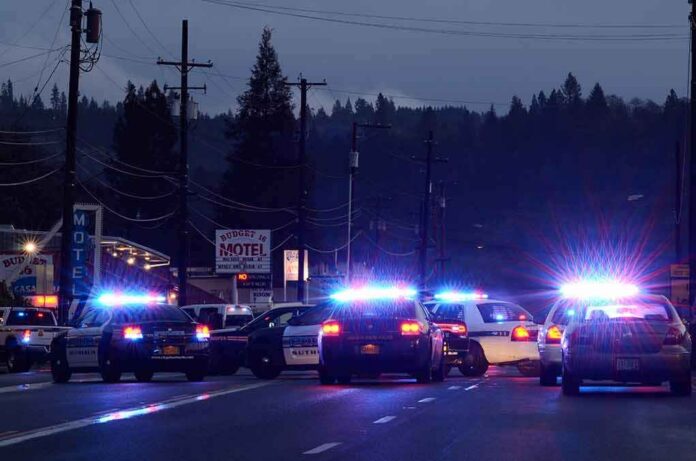 shutterstock_123247681 Police cars with flashing lights block a road at night