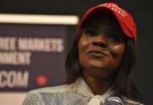 woman in a red cap speaking into a microphone