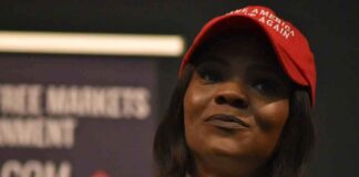 woman in a red cap speaking into a microphone