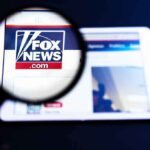 Fox New Hires Cuomo Aide – Backlash Erupts Magnifying glass over Fox News website logo on a tablet