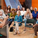 Dem Darling SUBPOENAED – 16 Violations! Audience listening to a speaker at a community meeting