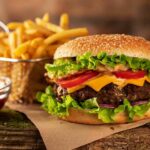 Cheeseburger with fries on rustic surface