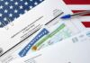 immigration forms with green card and social security card on US flag background