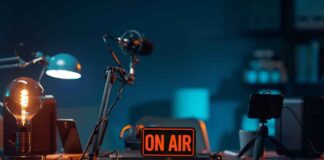 podcast studio desk with on air sign and microphones